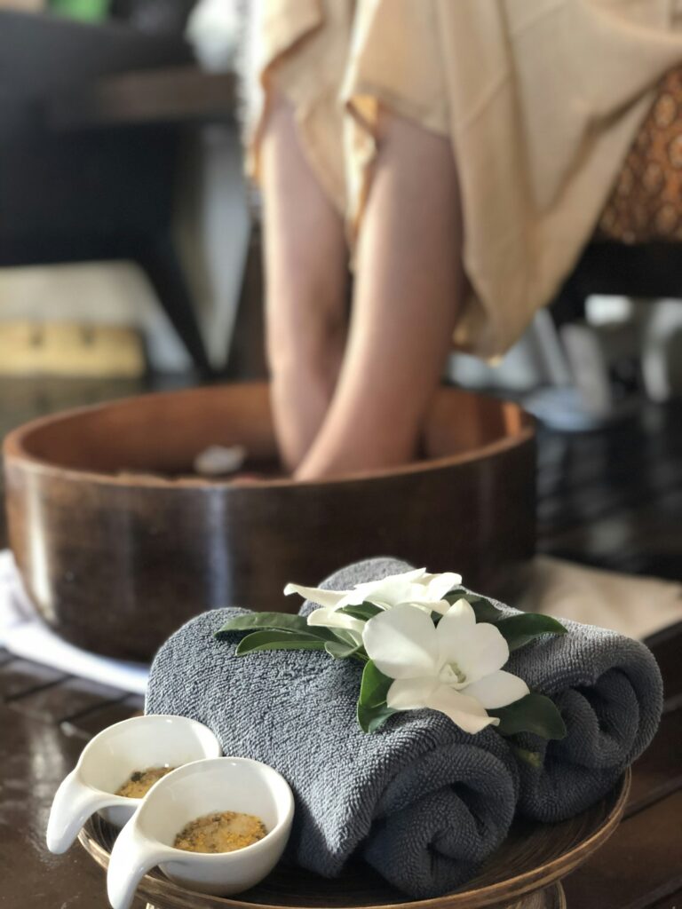 Kąpiel stóp w drewnianej misie przed pedicure