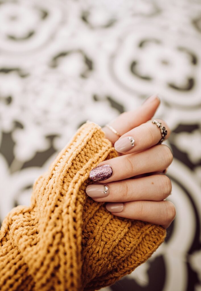 Manicure nude ze zdobieniem z brokatem
